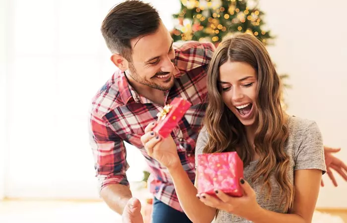 A boyfriend surprising his girlfriend with a gift.