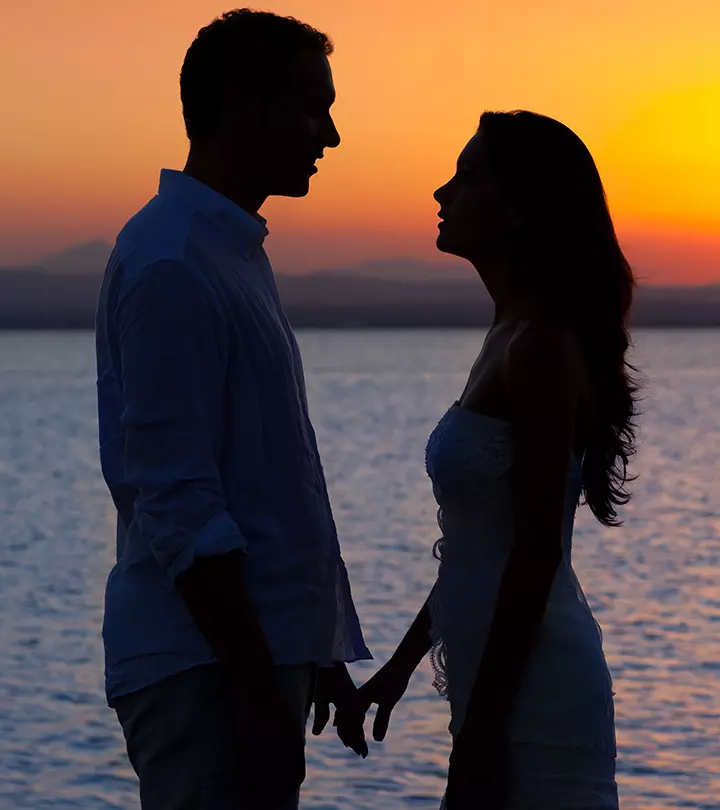 A couple standing near a lake