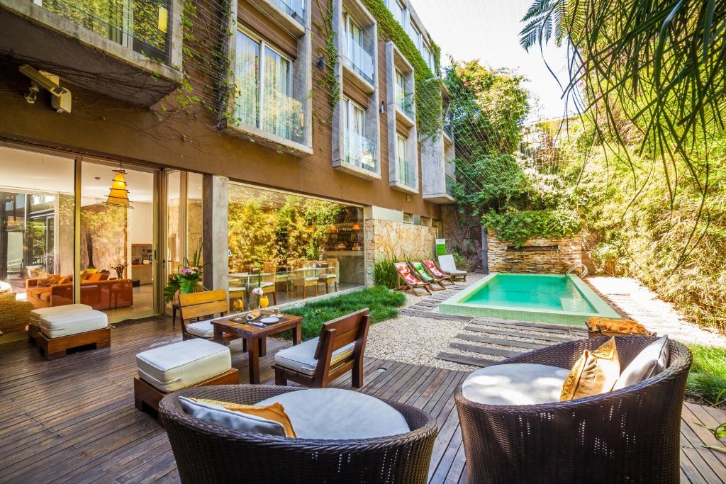 an outdoor patio with chairs and a swimming pool at Mine Hotel in Buenos Aires