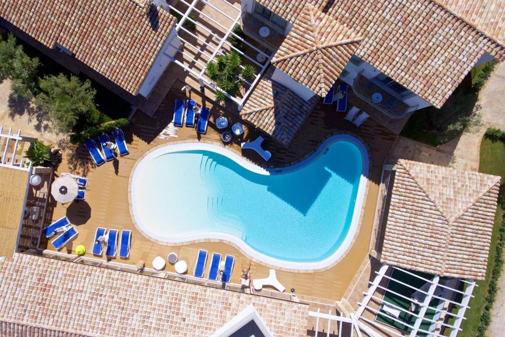 een uitzicht over een zwembad met stoelen en parasols bij Eliantos Boutique Hotel & Spa in Santa Margherita di Pula