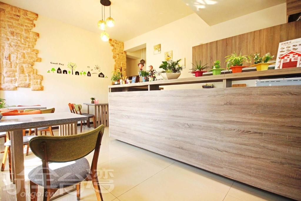 a restaurant with a wooden counter and tables and chairs at 八八小屋心享民宿 in Jinning