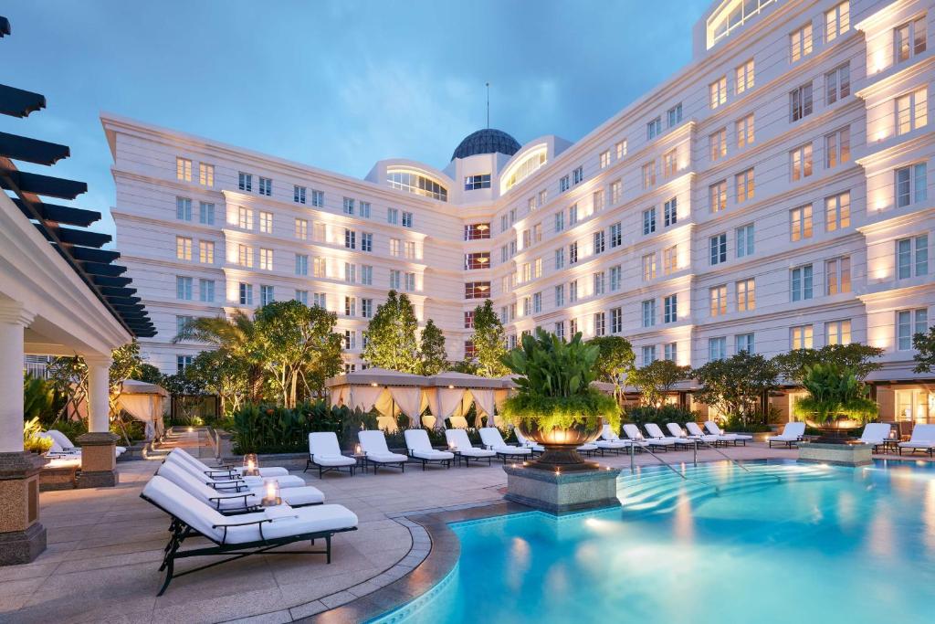 ein Hotel mit einem Pool vor einem Gebäude in der Unterkunft Park Hyatt Saigon in Ho-Chi-Minh-Stadt