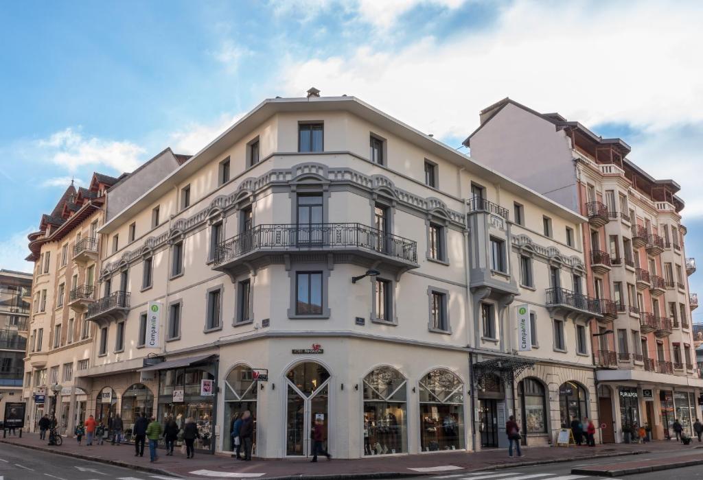 a white building on the corner of a street at Campanile Annecy Centre - Gare in Annecy