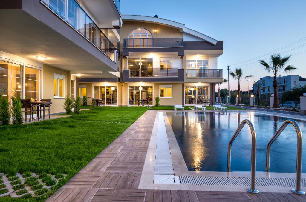 uma casa com uma piscina em frente em Lara Beach Homes em Antália