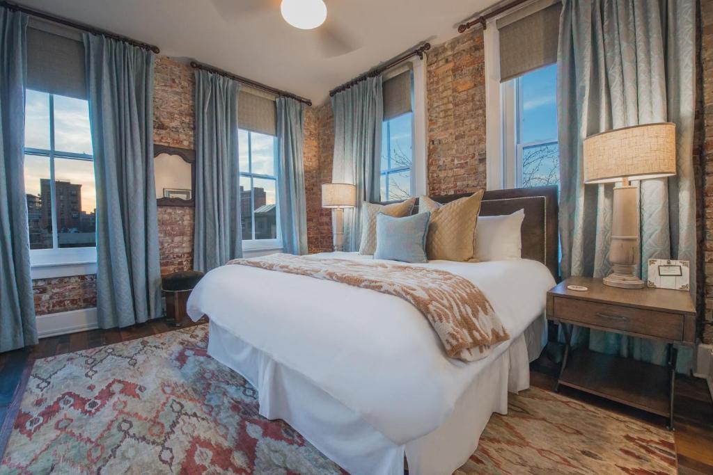 a bedroom with a large white bed and windows at The Windsor - Asheville in Asheville