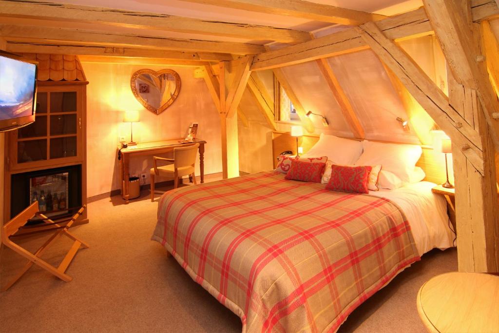 a bedroom with a bed and a fireplace and a tv at Hotel Beaucour in Strasbourg