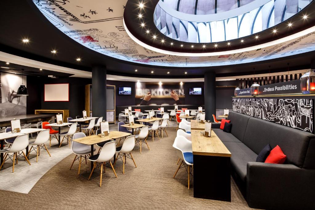 een restaurant met tafels en stoelen en een groot plafond bij ibis Birmingham Centre New Street Station Hotel in Birmingham