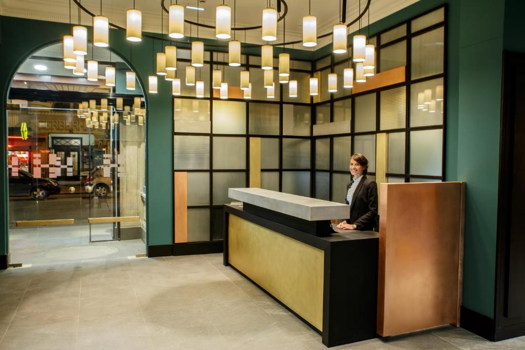 a man is sitting at a counter in a lobby at HANNONG Hotel & Wine Bar in Strasbourg