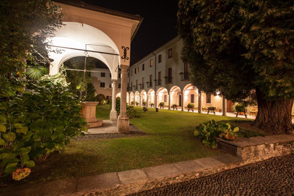 a courtyard of a building at night with a tree at Hotel Il Chiostro by LVG Hotel Collection in Verbania