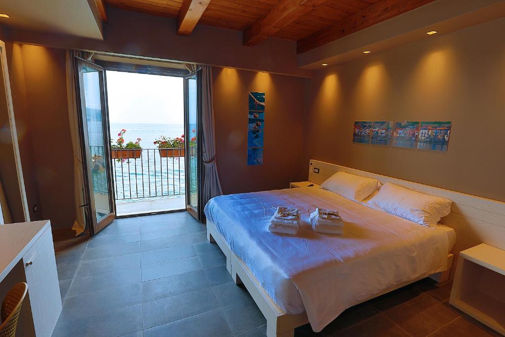 a bedroom with a large bed and a large window at Il Casato Deluxe Rooms in Scilla