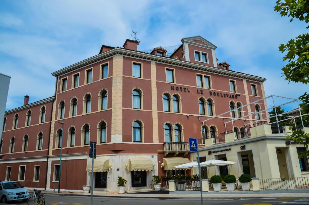 un grande edificio in mattoni rossi all'angolo di una strada di Hotel Le Boulevard a Lido di Venezia