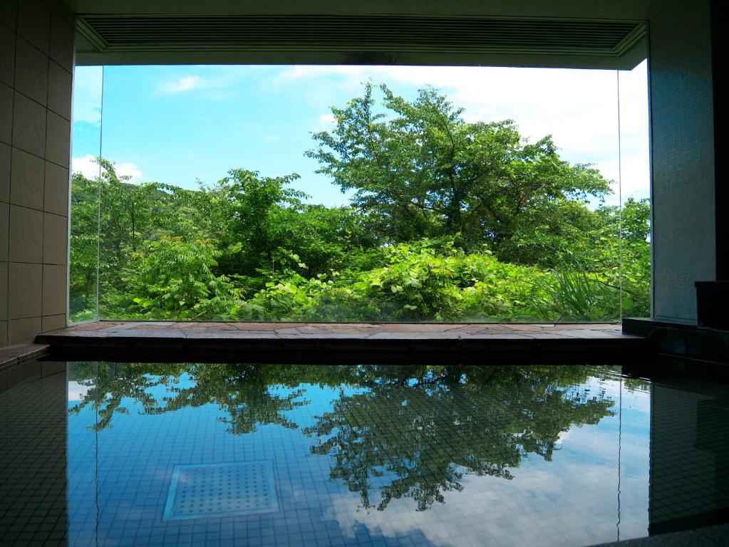 a swimming pool with a view of a tree at Wisterian Life Club Usami in Ito