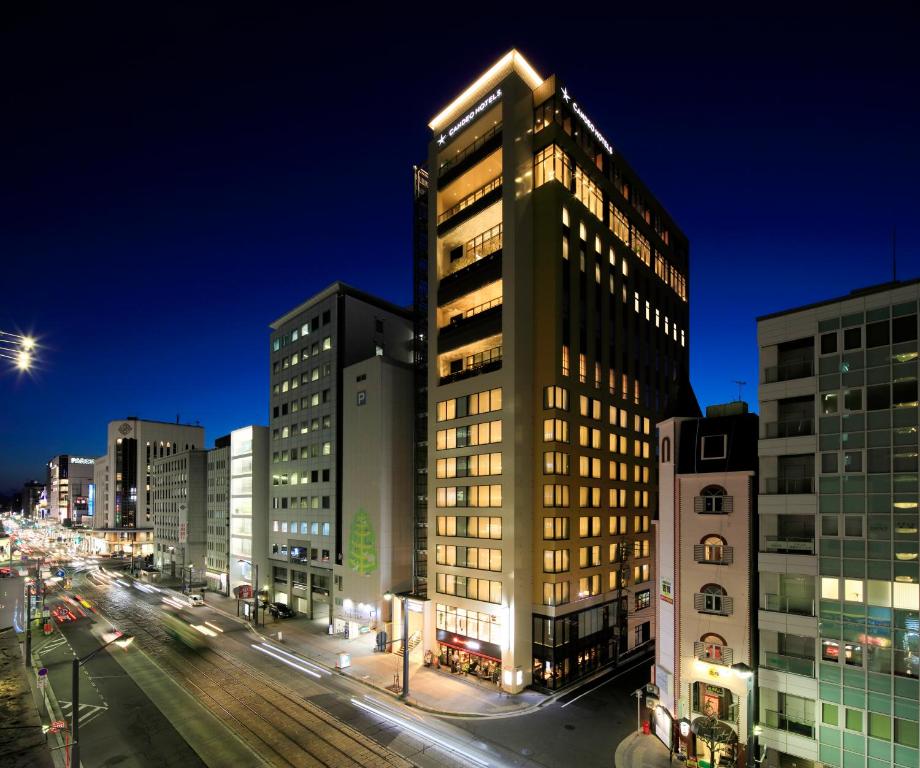 Un palazzo alto in una strada di città di notte di Candeo Hotels Hiroshima Hatchobori a Hiroshima