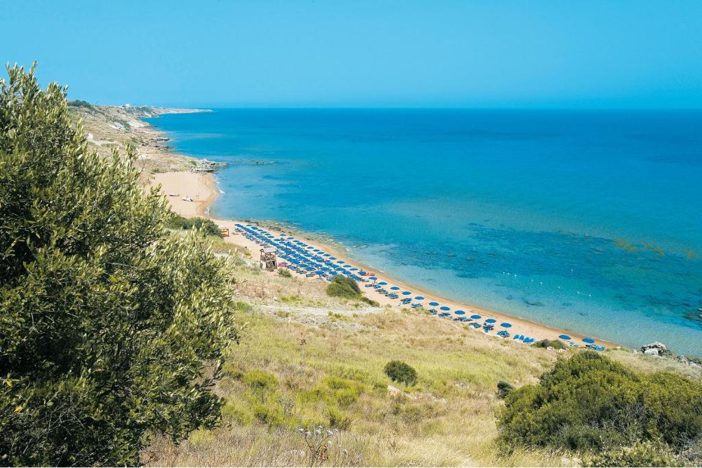 plaża z parasolami i oceanem w obiekcie Villaggio L'Oasi w mieście Isola Capo Rizzuto