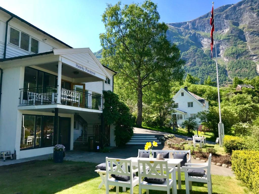 - un bâtiment avec une table et des chaises dans la cour dans l'établissement Heimly Pensjonat, à Flåm