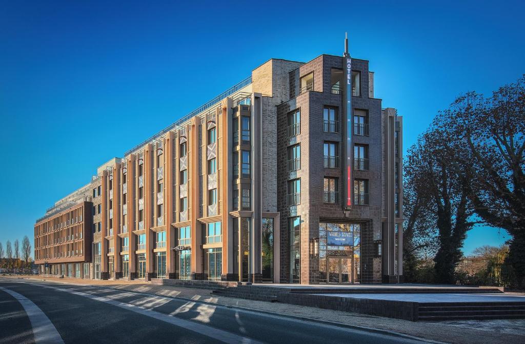 een groot bakstenen gebouw aan de kant van een straat bij Grand Hotel Valies in Roermond