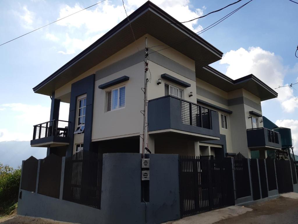 una casa con una recinzione di fronte di Restful 3BR Hillside Duplex House a Baguio