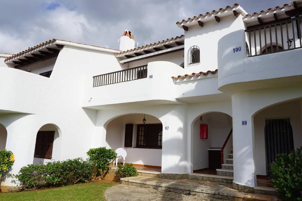 uma grande casa branca com uma varanda em Apartamento el Descanso em Son Bou