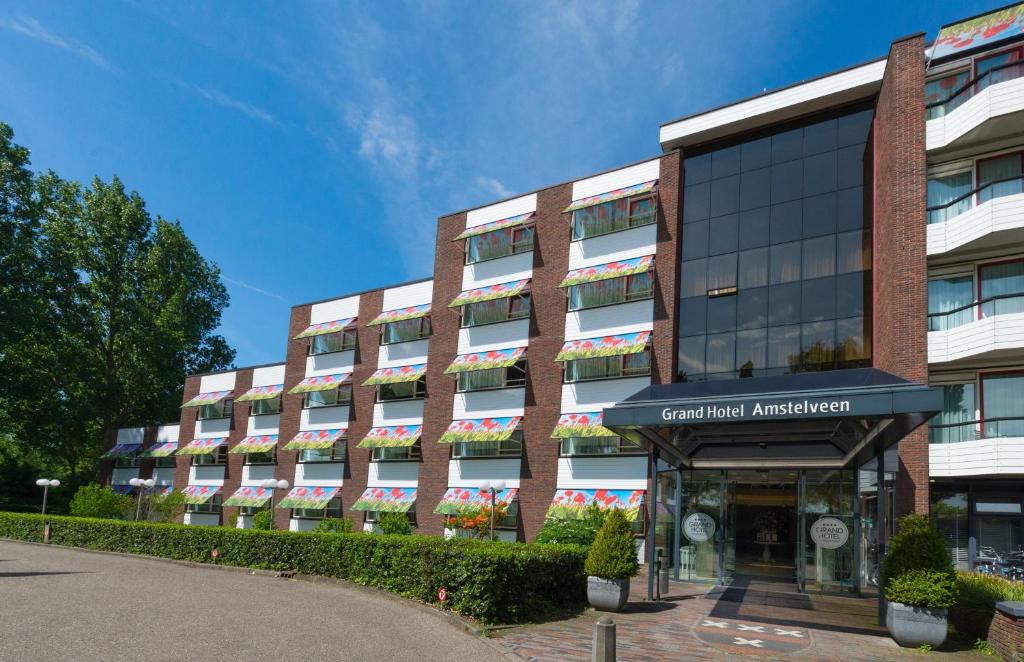 een groot bakstenen gebouw met een gebouw bij Grand Hotel Amstelveen in Amstelveen