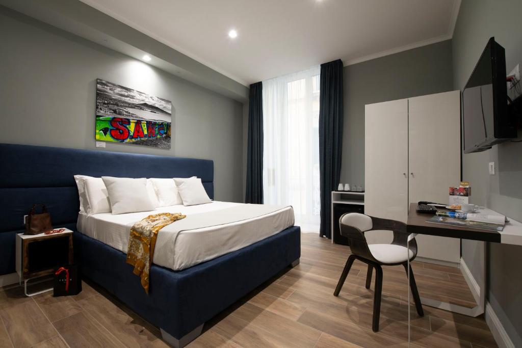 Habitación de hotel con cama, escritorio y silla en Dante Maison de Prestige, en Nápoles