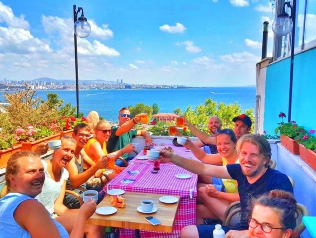 un grupo de personas sentadas alrededor de una mesa con bebidas en Cheers Vintage Hostel, en Estambul