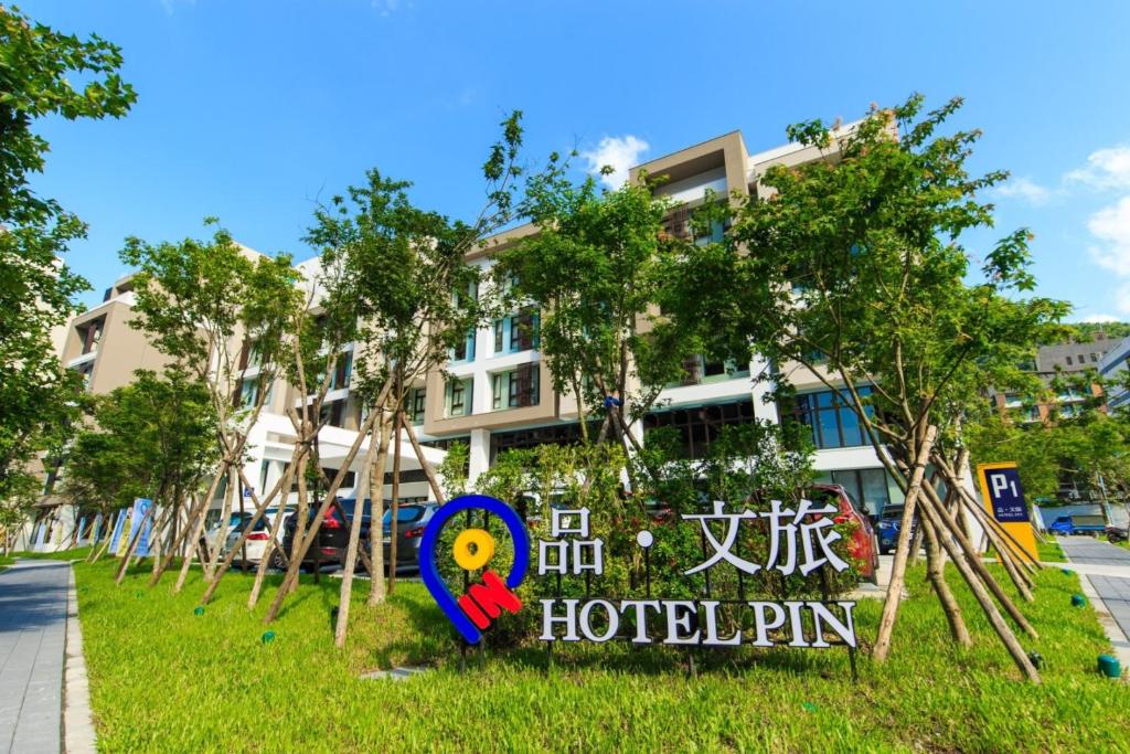 un panneau dans l'herbe devant un hôtel dans l'établissement HOTEL PIN Jiaoxi, à Jiaoxi