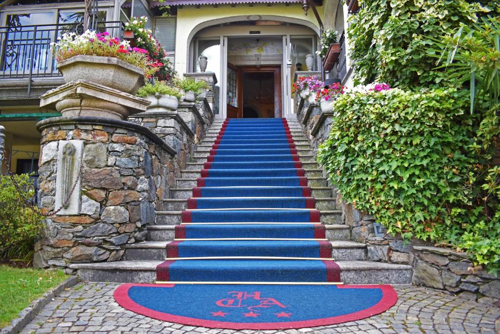 a stairway with a blue and red carpet in front of a house at Albergo Ristorante Conca Azzurra in Colico