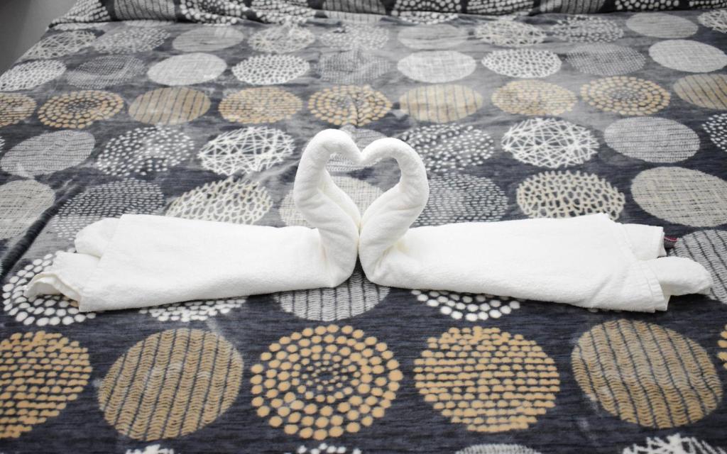 two white swans making a heart on a bed at HOTEL LOS PINOS CENTRO in Tuxtla Gutiérrez