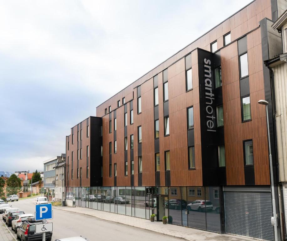 a building on a street with a parking lot at Smarthotel Tromsø in Tromsø