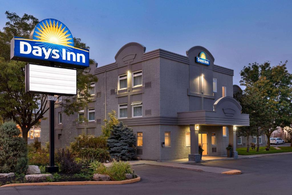 a building with a days inn sign in front of it at Days Inn by Wyndham Toronto West Mississauga in Mississauga