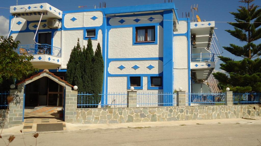 un edificio azul y blanco con una puerta en Panorama Hotel, en Ammoudia