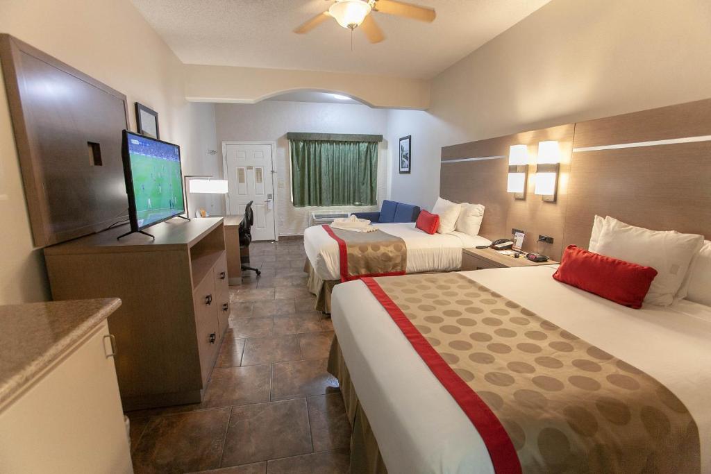 Cette chambre comprend 2 lits et une télévision à écran plat. dans l'établissement Ramada by Wyndham & Suites South Padre Island, à South Padre Island