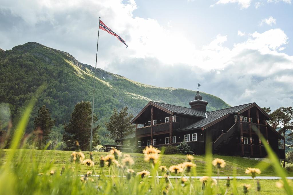 un edificio con una bandiera in un campo con fiori di Toftemo Turiststasjon a Dovre