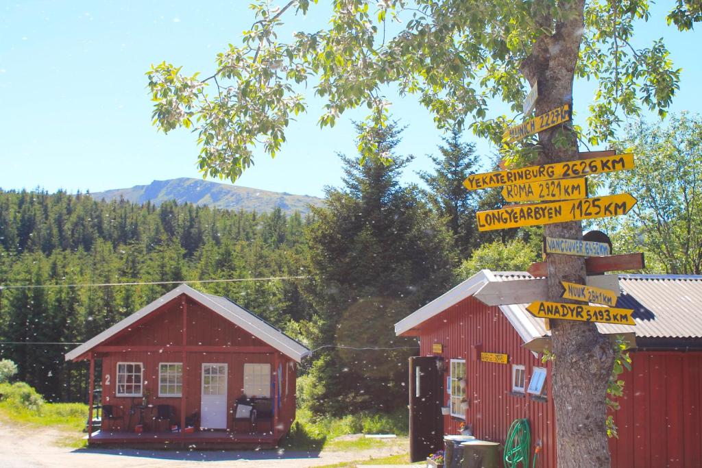 un panneau de rue devant un bâtiment rouge dans l'établissement Lofoten Camp, à Stamsund