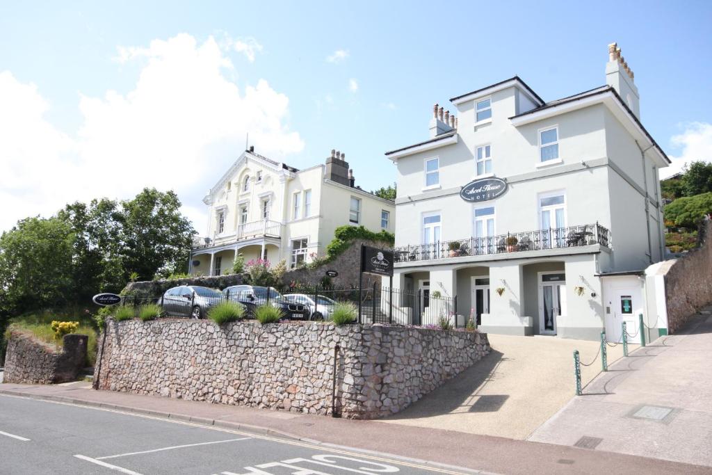 un edificio blanco con coches estacionados frente a él en Ascot House Hotel, en Torquay