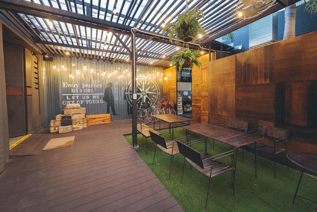 a patio with a table and chairs in a building at Westory Design Poshtel in Kanchanaburi City