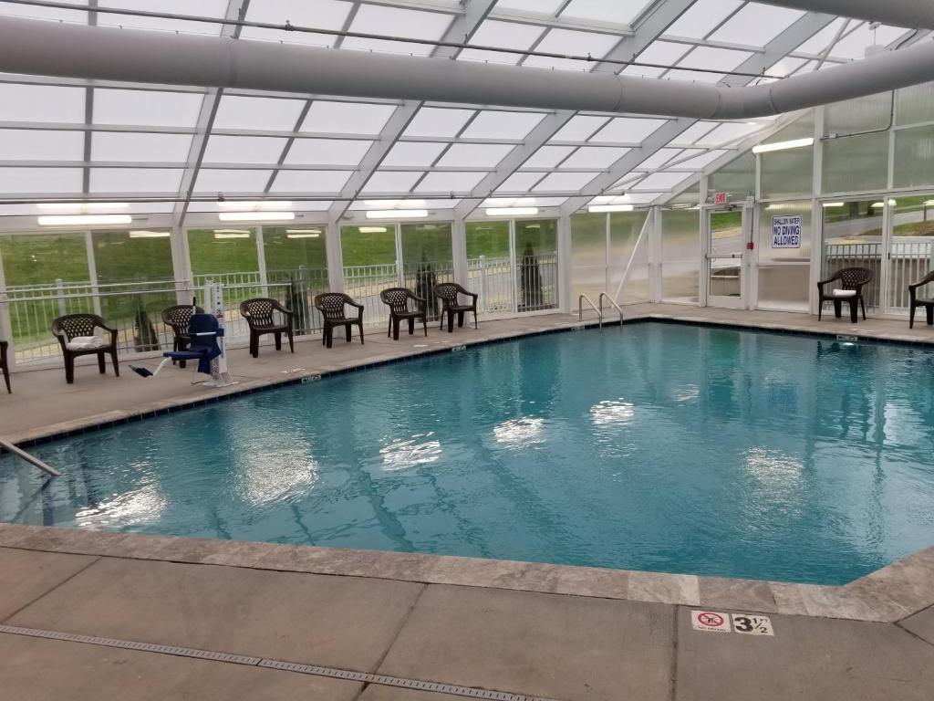 ein großer Pool mit Tischen und Stühlen in einem Gebäude in der Unterkunft Vacation Lodge in Pigeon Forge