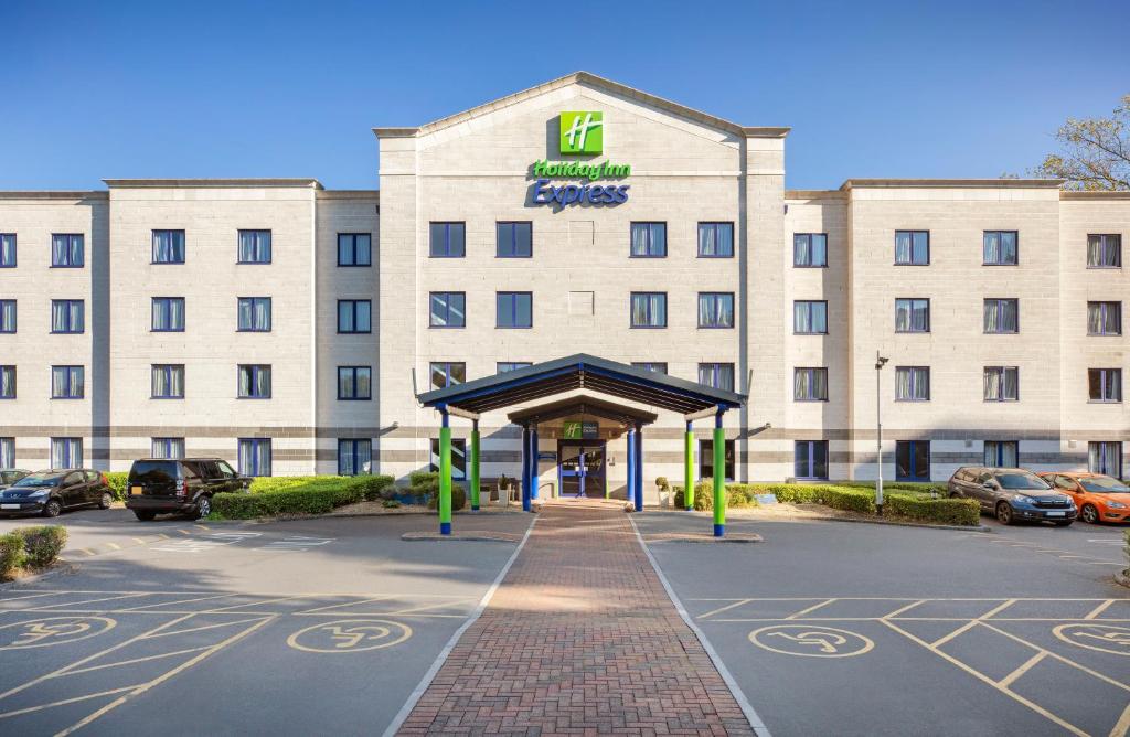 Holiday Inn Express Poole, an IHG Hotel في بول: فندق مقابل مبنى فيه مواقف