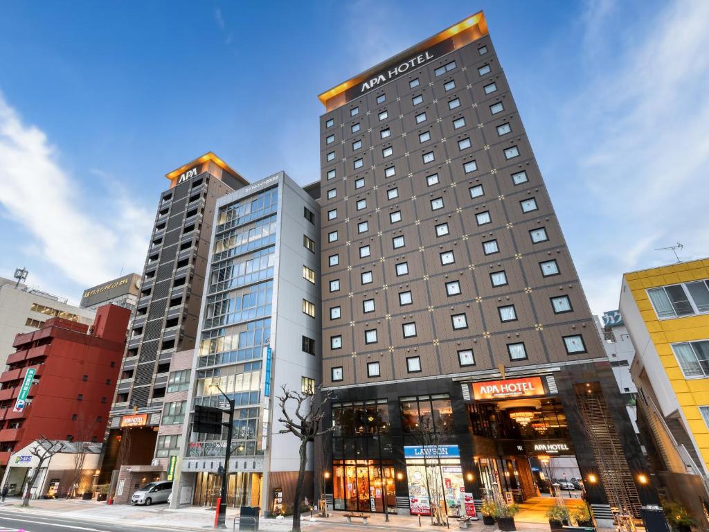 a tall building on a city street with buildings at APA Hotel Hiroshima Ekimae Ohashi in Hiroshima