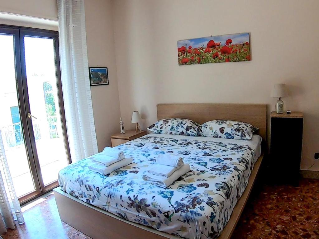 a bedroom with a bed with a blue and white comforter at La Casa di Aurora in Reggio di Calabria