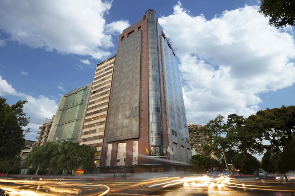 a tall glass building with a street in front of it at Grand Fiesta Americana Chapultepec in Mexico City