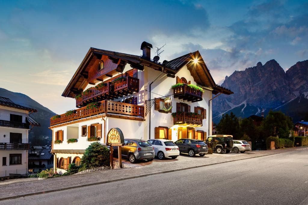 a building with cars parked in front of it at Hotel Natale in Cortina dʼAmpezzo