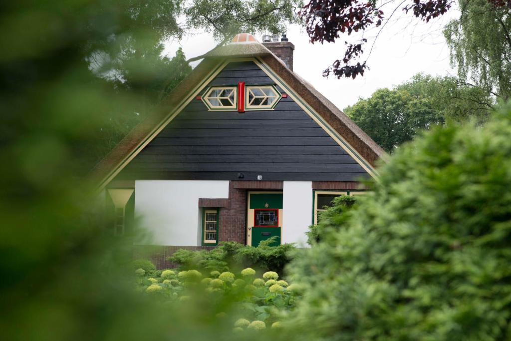 uma casa com uma porta verde e janela vermelha em Huize Florinata em Voorthuizen