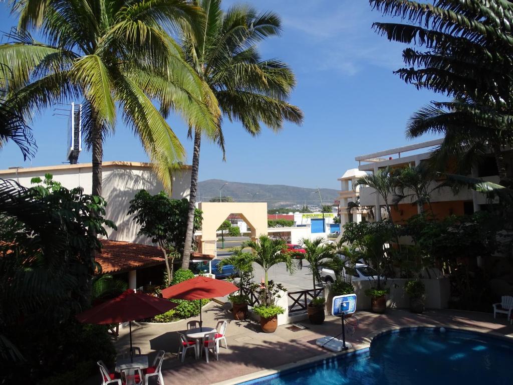 a view of a resort with a pool and palm trees at Hotel Palapa Palace in Tuxtla Gutiérrez