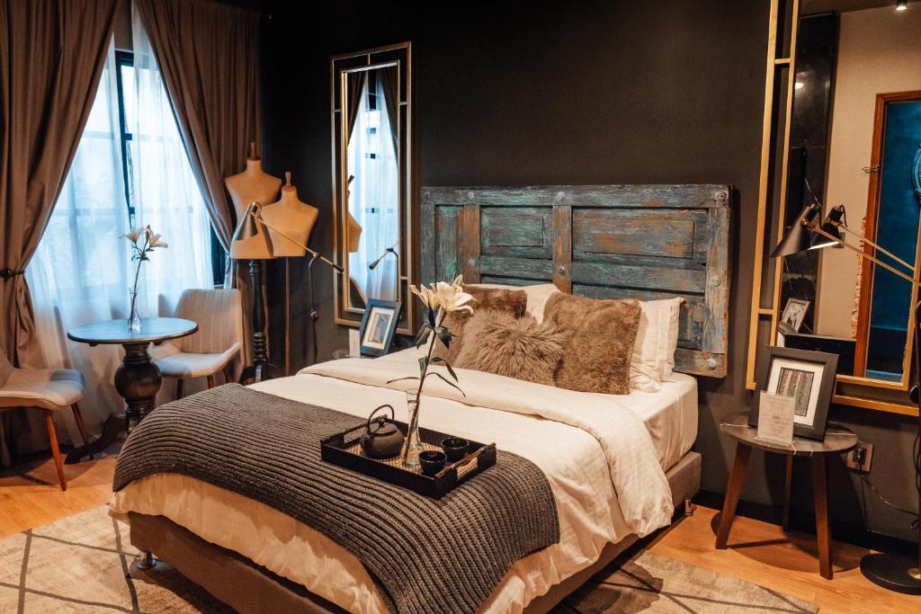 a bedroom with a large bed with a wooden headboard at CASA EMILIA B&B Boutique in Mexico City