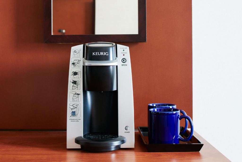 a coffee maker in a box next to a mug at Club Quarters Hotel Rittenhouse Square, Philadelphia in Philadelphia