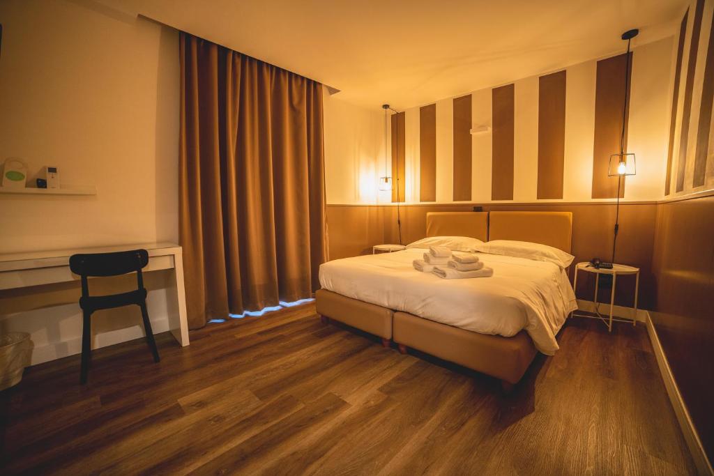 a hotel room with a bed and a desk at Hotel Continental in Reggio di Calabria