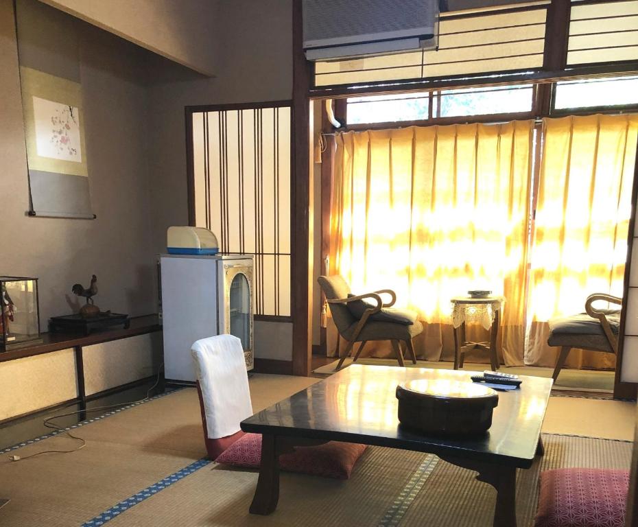 - un salon avec une table et une grande fenêtre dans l'établissement Izuya Ryokan - Vacation STAY 22369v, à Yugawara