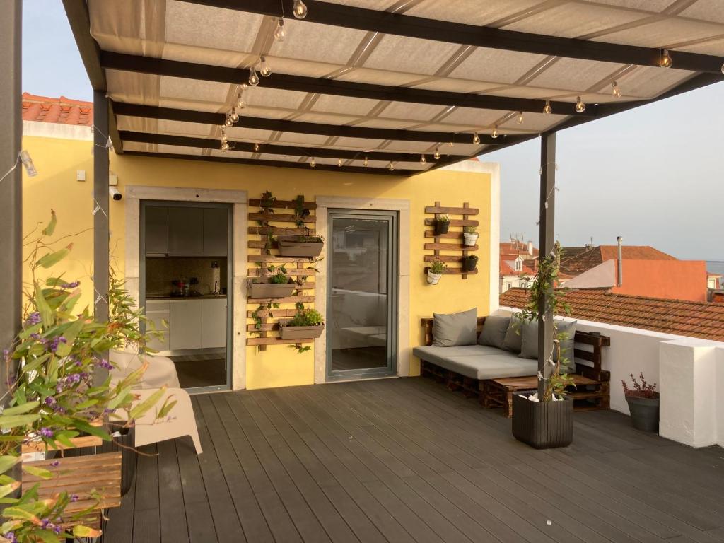 eine Terrasse mit einem Sofa unter einer Pergola in der Unterkunft Day Off Suite&Hostel in Setúbal