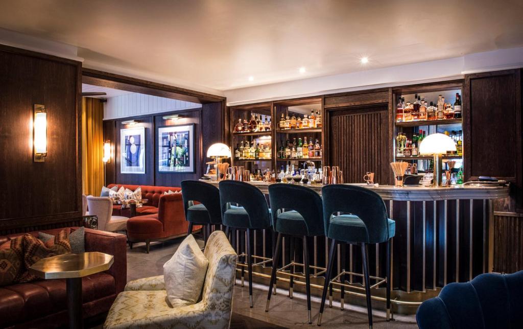 a bar in a restaurant with blue chairs at The Marylebone Hotel in London